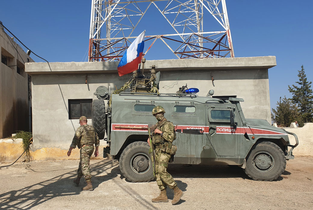 Russian soldiers walk past a Russian military police armoured vehicle at a position in the northeastern Syrian city Kobani, October 2019. (Getty/AFP)