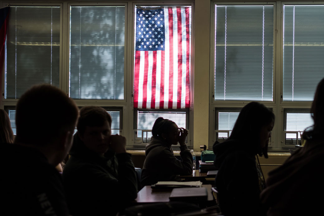  (High school students sit through class under a U.S. flag in Sidney, Ohio, October 2019.)