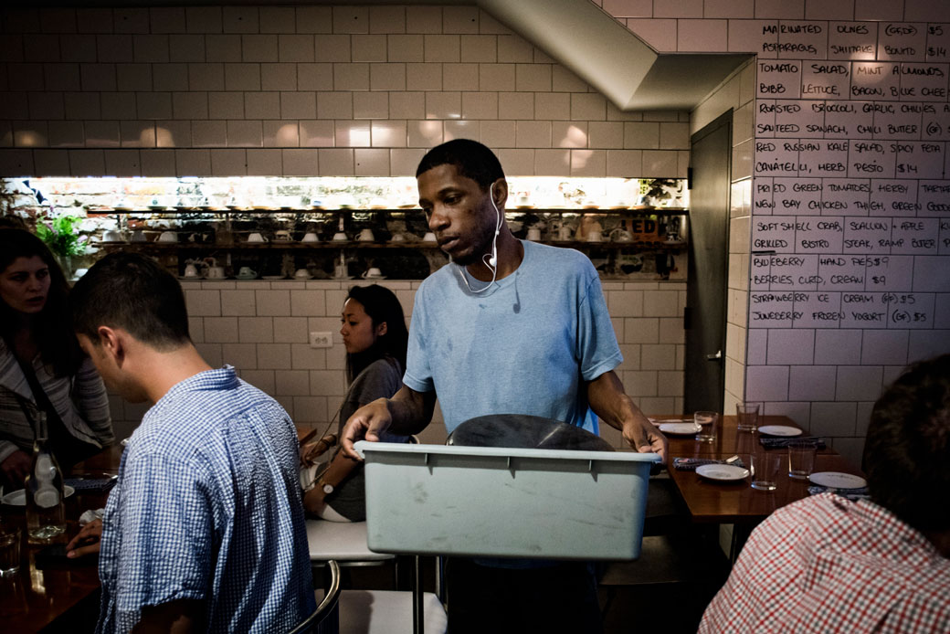 A dishwasher walks through the dining room at a restaurant in Washington, D.C., June 2016. (Getty/J. Lawler Duggan/The Washington Post)