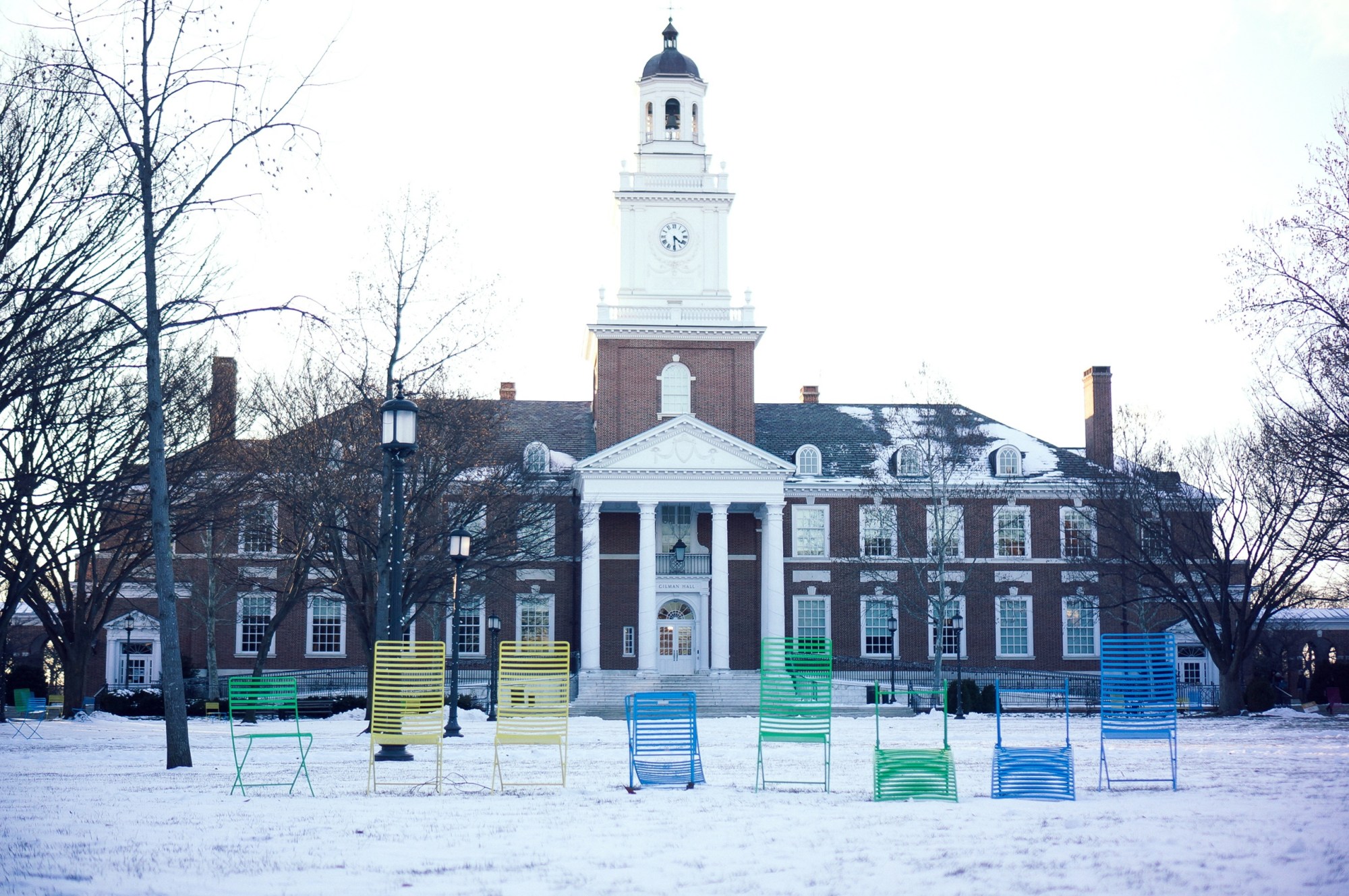 Several multicolored lawn chairs are lined up in front of Gilman Hall on the snowy Keyser quadrangle on the Homewood campus of the Johns Hopkins University in Baltimore, Maryland, January 2015. (Getty/JHU Sheridan Libraries)