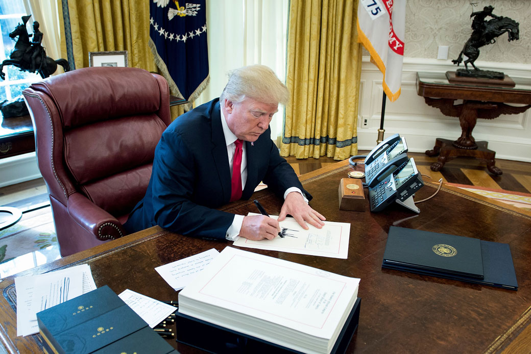  (President Donald Trump signs the Tax Cuts and Jobs Act at the White House in Washington, D.C., on December 22, 2017.)