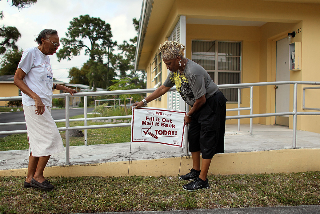 A U.S. Census volunteer places a sign in front of a resident's home in Miami as part of an effort to boost mail response rates in hard-to-count communities, April 2010. (Getty/Joe Raedle)