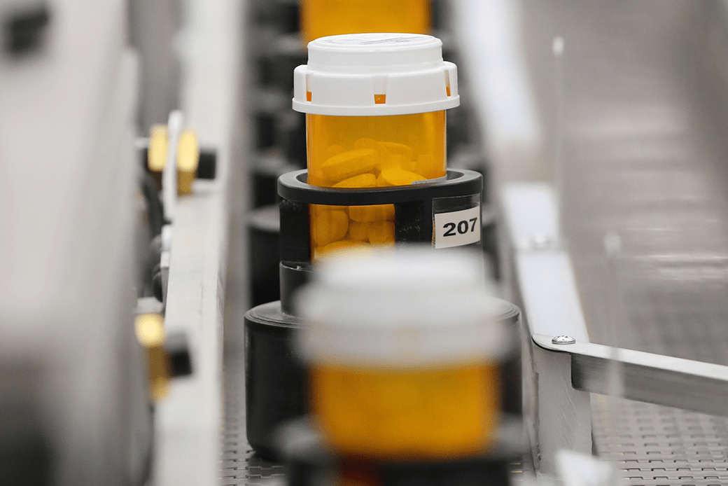  (Bottles of prescription drugs are shown being filled on an automated line.)