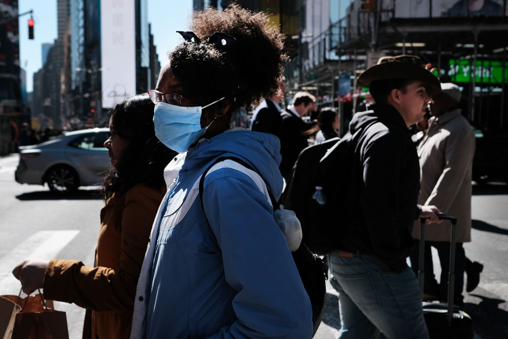 People walk through Manhattan with surgical masks as fears of the novel coronavirus outbreak increase in the United States, March 2020. (Getty/Spencer Platt)