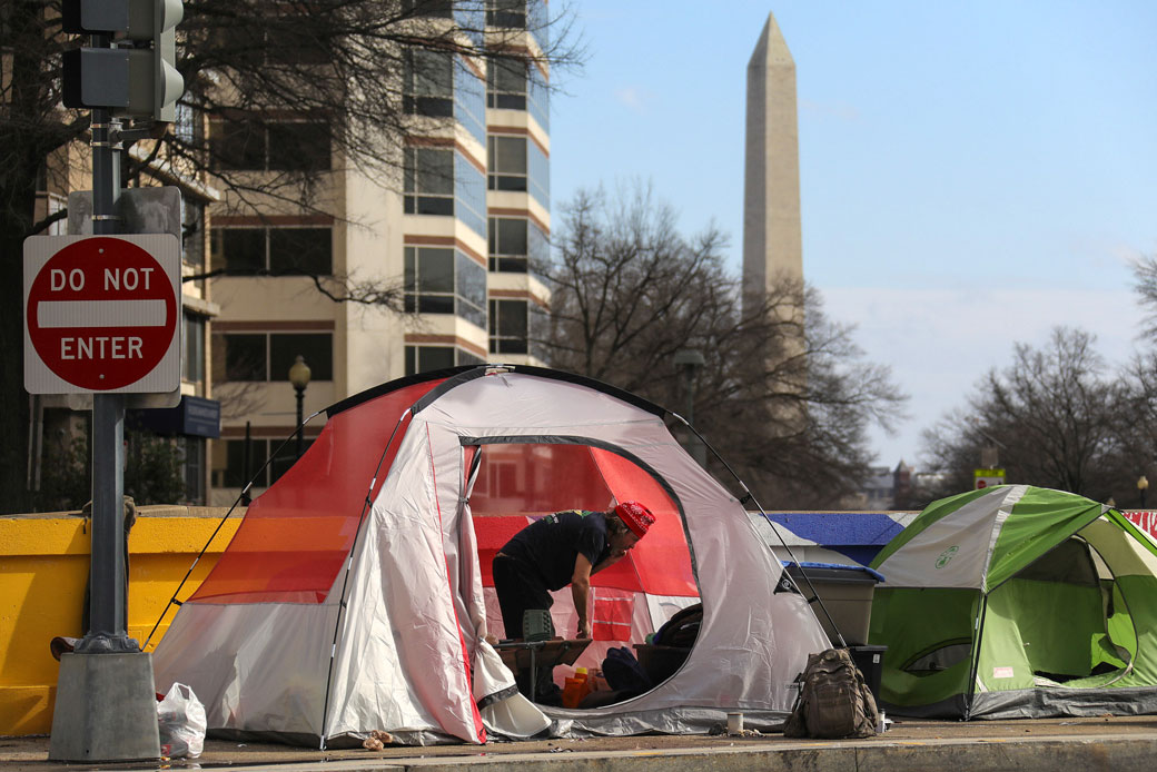 A man in a tent stands among other shelters belonging to people experiencing homelessness in Washington, D.C., February 2020. (Getty/Valery Sharifulin/TASS)
