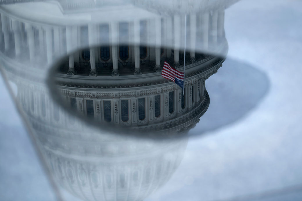 The U.S. Capitol is reflected in water as negotiations on a COVID-19 economic bailout continue on March 24, 2020, in Washington, D.C. (Getty/Brendan Smialowski/AFP)