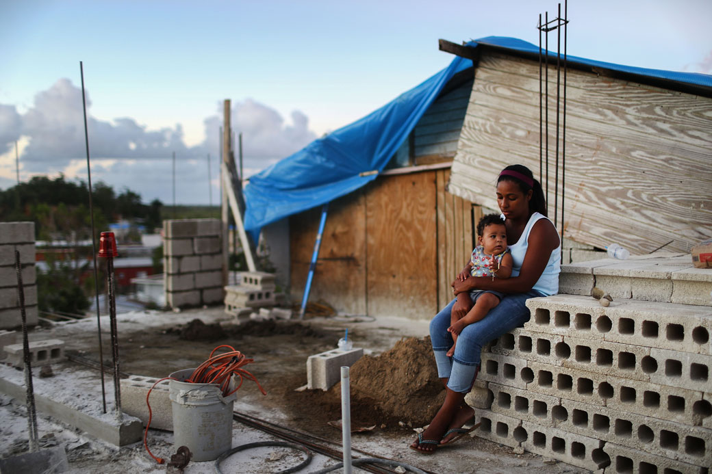A mother holds her baby at their home, which is under construction after being mostly destroyed by Hurricane Maria, in San Isidro, Puerto Rico, December 2017. (Getty/Mario Tama)