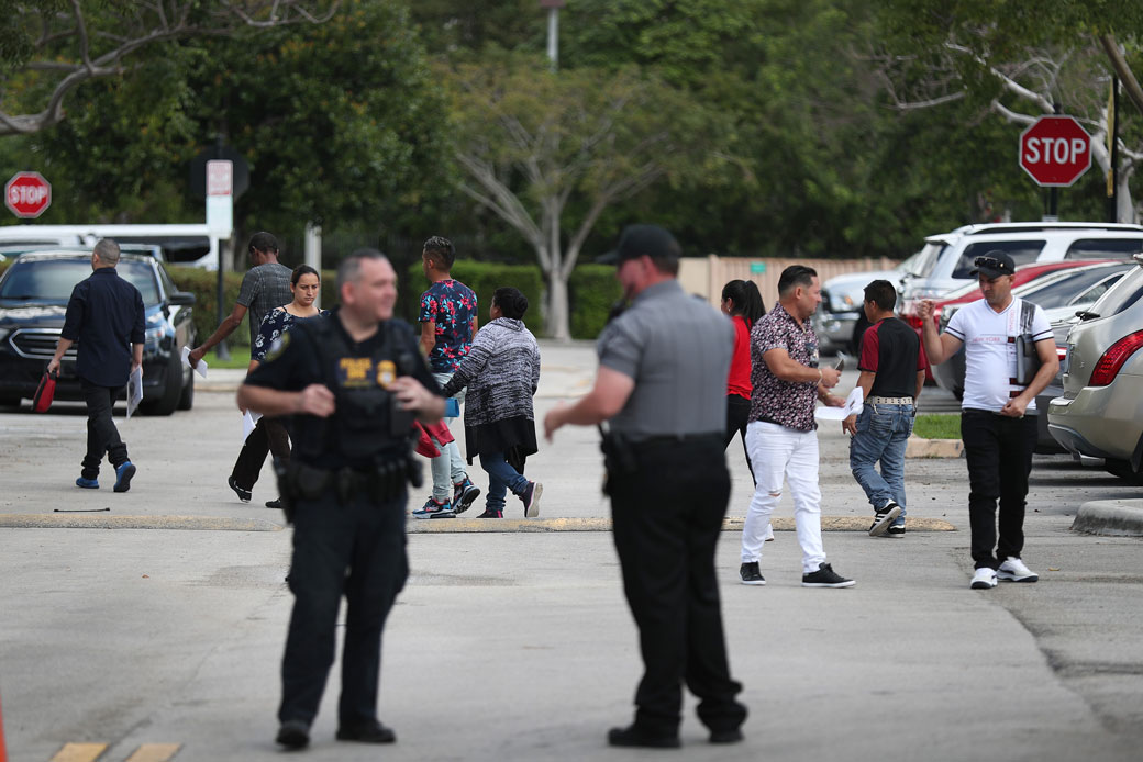 People walk through the parking lot as they visit the U.S. Immigration and Customs Enforcement (ICE) office in Miramar, Florida, on March 13, 2020. (Getty/Joe Raedle)