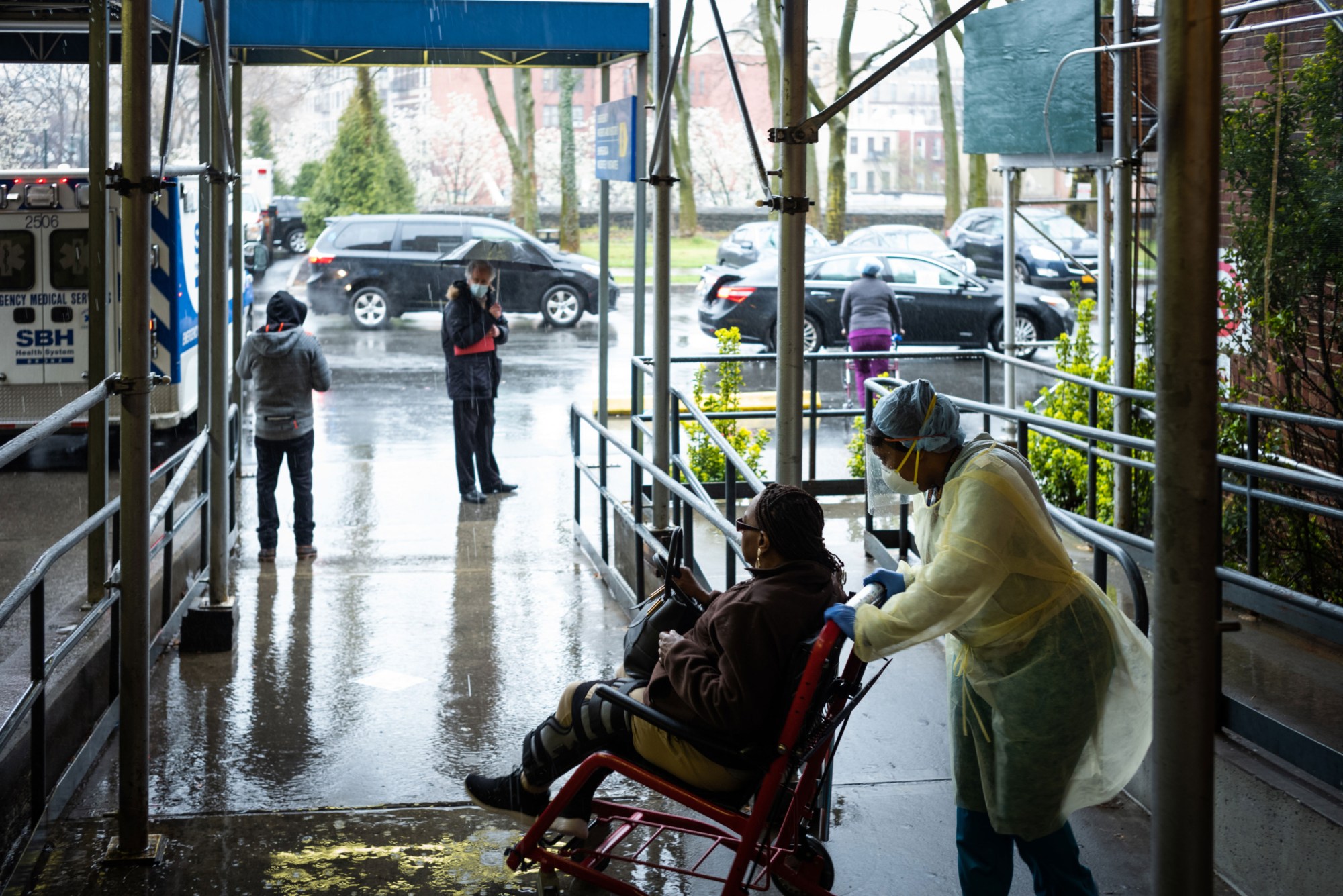 A staff member pushes a patient in a wheelchair at a New York City hospital, March 2020. (Getty/Misha Friedman)