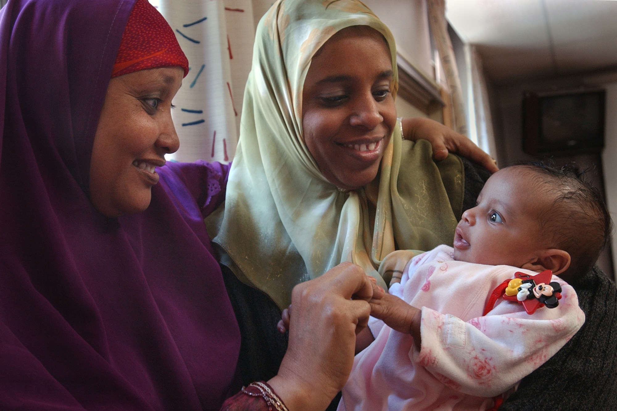 Joey McLeister/Star Tribune Minneapolis,Mn.,Thurs.,April 22, 2004--(Left to right) Hawa Ade was Muna Said Mohamed's doula for the birth of her eighth baby, two-month-old Mariam Mohamed at Fairview University Hospital.  Ade is a doula at Hennepin County Medical Center, too.  Mohamed said she was grateful for the massages from Ade which eased the pain of labor. GENERAL INFORMATION: At Fairview University Hospital, Somali women are helped by Somali doulas before and during birth. (Photo by JOEY MCLEISTER/Star Tribune via Getty Images) (A doula sits with a mother and her 2-month-old baby at a hospital in Minneapolis, April 2004.)