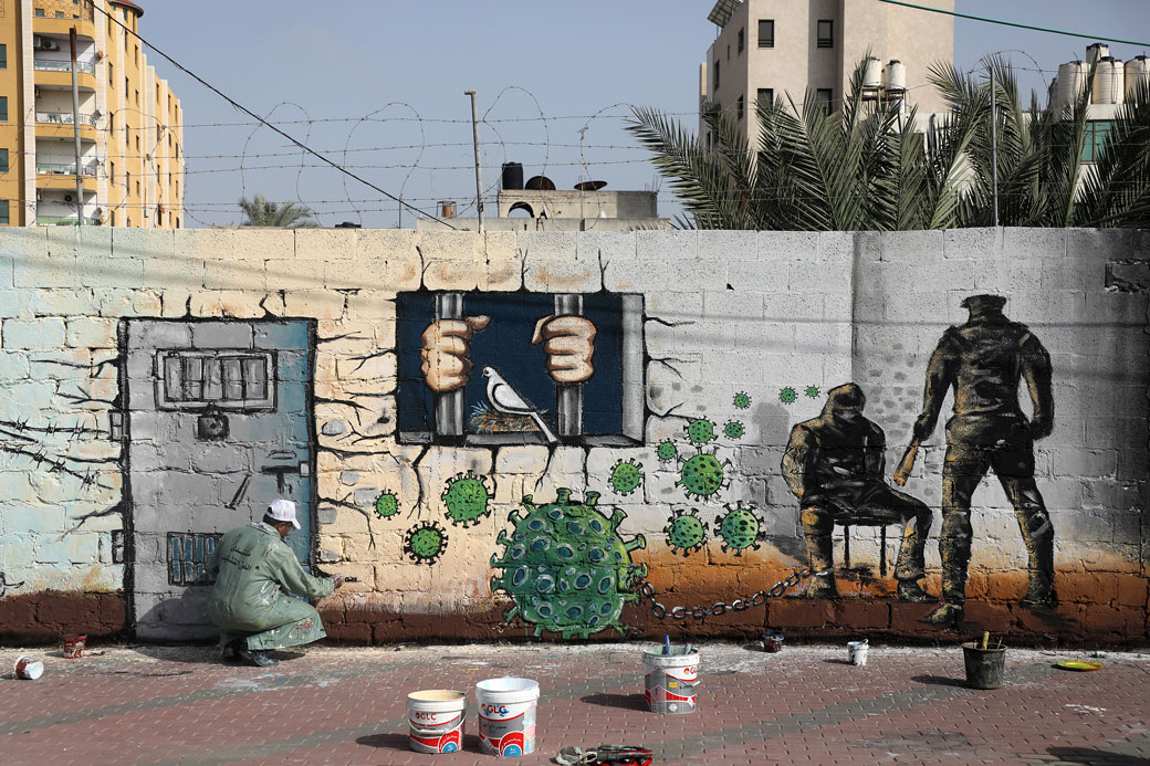An artist paints a mural in Gaza City on April 20, 2020. (Getty/Majdi Fathi)