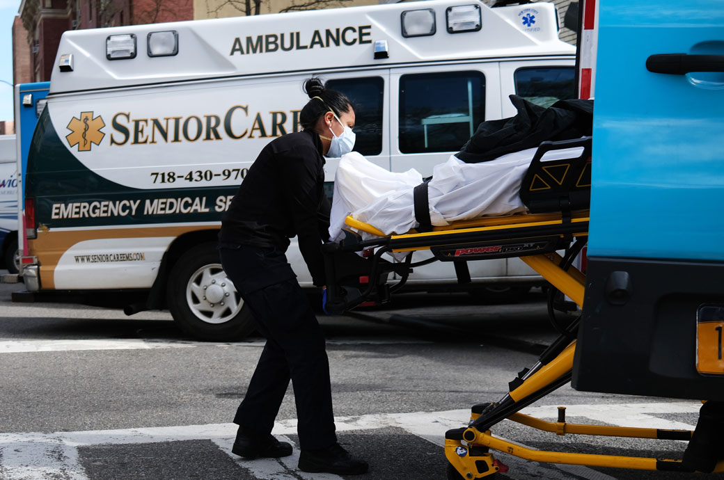 A health worker lifts a patient in to an ambulance, April 2020. (Getty/Spencer Platt)