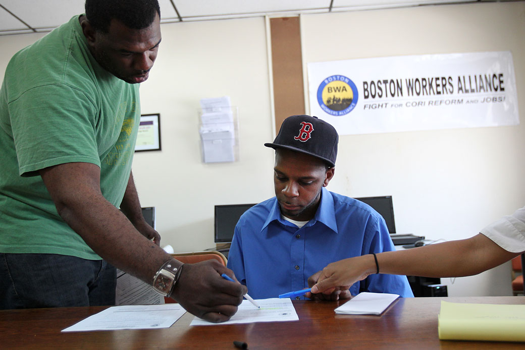 A staffer at a Boston Workers Alliance office shows a job applicant how he can apply to get his criminal record sealed, June 2011 (Getty/The Boston Globe/Suzanne Kreiter)