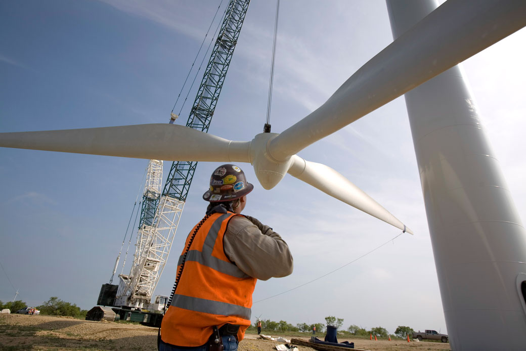 A crane slowly lifts a rotor onto a tower at a wind farm north of Abilene, Texas, June 2007. (Getty/Robert Nickelsberg)