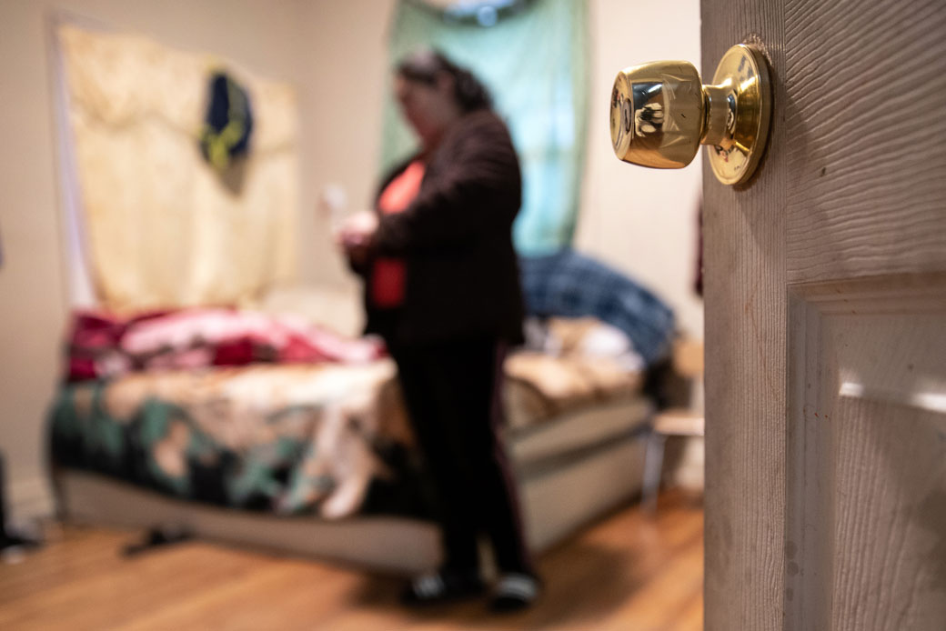 A woman stands in her bedroom while self-quarantining in a Long Island rental house with her family, March 2020. (Getty/John Moore)