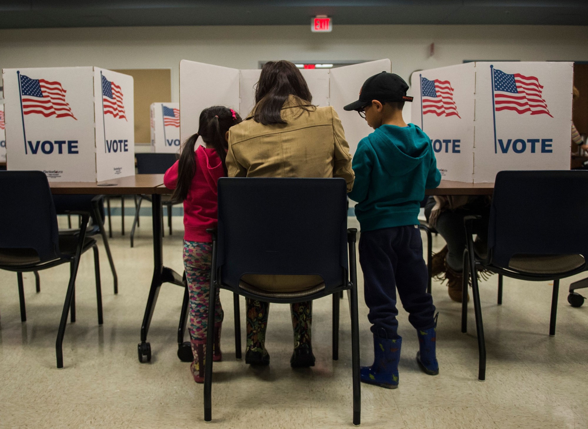A woman and her children vote at a polling station during the midterm elections at the Fairfax County bus garage in Lorton, Virginia, on November 6, 2018. (Getty/Andrew Caballero)