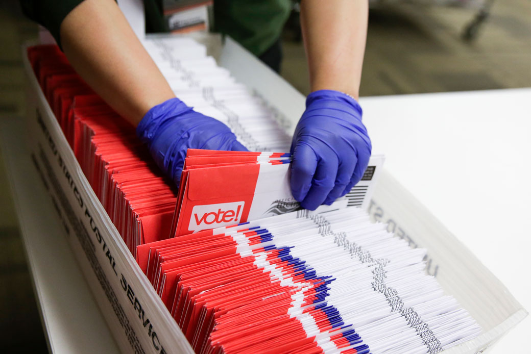 Election workers wearing gloves sort vote-by-mail ballots for the presidential primary in Renton, Washington, on March 10, 2020. (Getty/Jason Redmond/AFP)