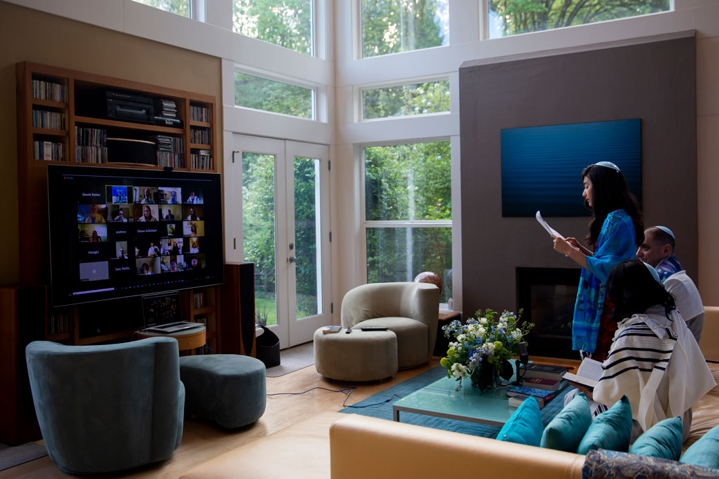 A girl performs a Torah reading to family, friends, and members of her congregation as she celebrates her bat mitzvah at home in Redmond, Washington, due to the coronavirus pandemic, April 2020. (Getty/Lindsey Wasson)