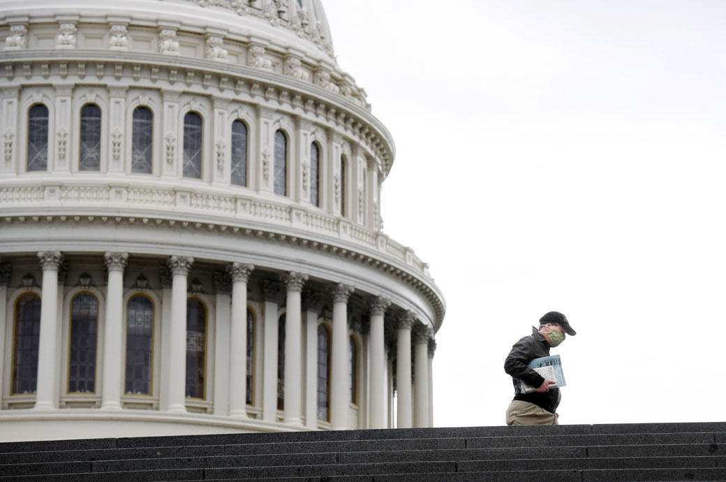 A pedestrian wears a mask while walking near the U.S. Capitol, April 2020. (Getty/Matt McClain)