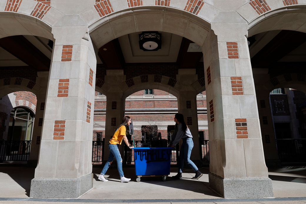  (Two students move out of their campus dorms at a university in Michigan following World Health Organization guidance during the coronavirus pandemic, March 2020.)