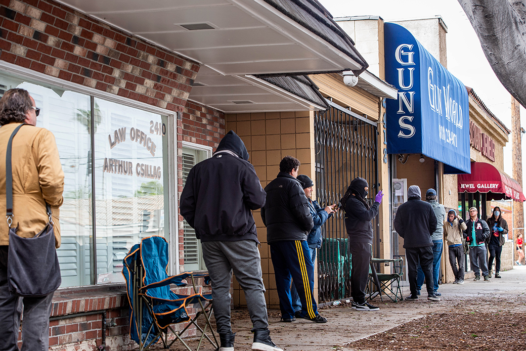 (Shoppers wait in line outside of a Gun World store.)