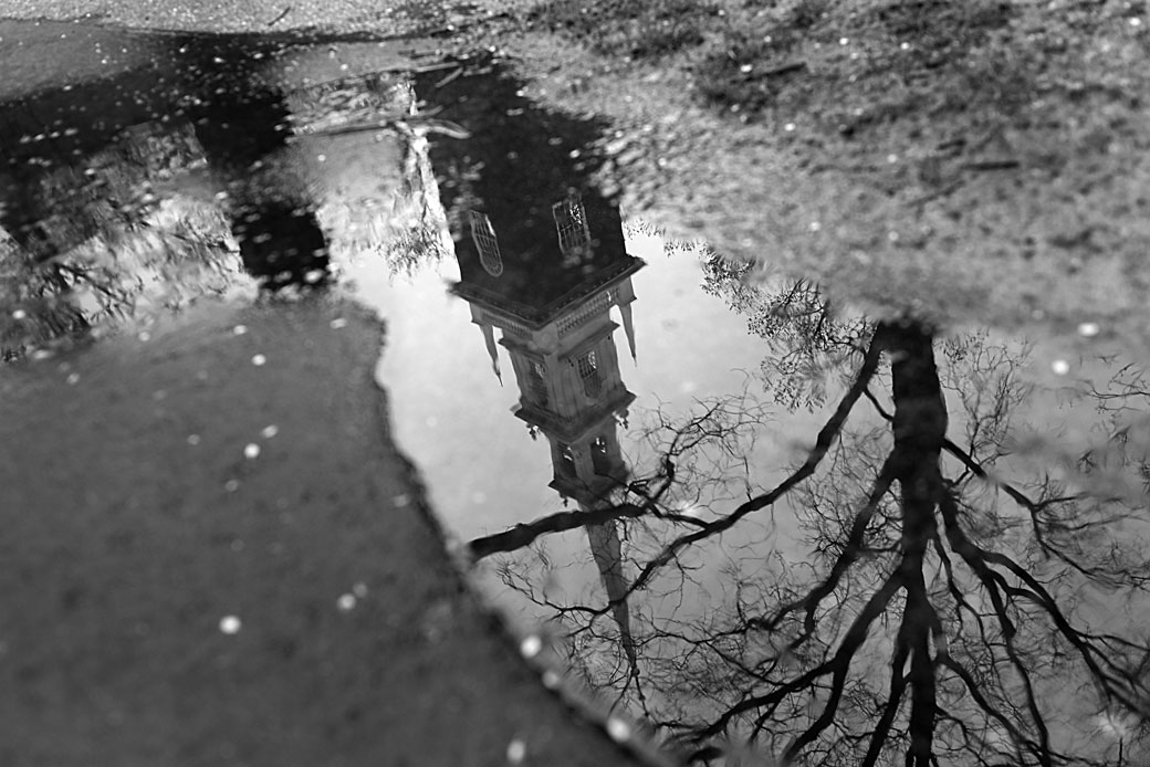 A building on a university campus in Massachusetts is seen reflected in a puddle on April 27, 2020. (Getty/Suzanne Kreiter/The Boston Globe)