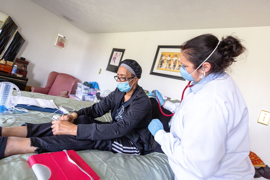 An in-home nurse cares for a woman as she continues to recover from COVID-19 at her home in Baltimore, May 2020. (Getty/Arturo Holmes)