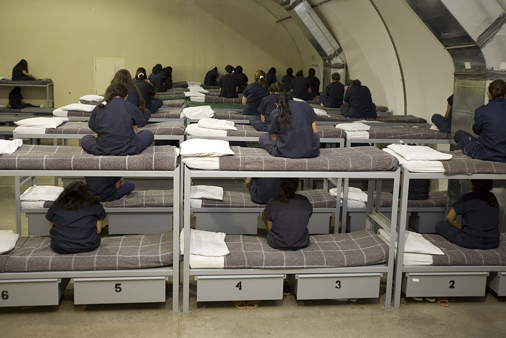 Female detainees turn their backs to the visiting media, as instructed by Homeland Security officials, inside a Homeland Security immigration detention center in Texas, 2007. (Getty/Paul J. Richards and STR)