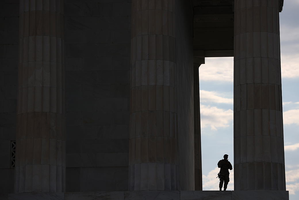 A member of the D.C. National Guard takes advantage of the shade at the Lincoln Memorial as demonstrators citywide participate in peaceful protest against police brutality and the death of George Floyd, June 3, 2020 in Washington. (Getty/Win McNamee)
