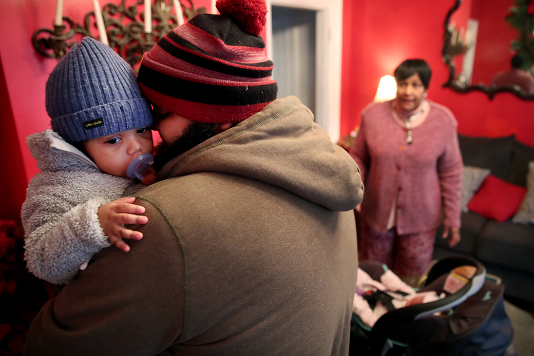 A parent picks up his son while a child care provider  looks on in Boston, Massachusetts, March 2020. (Getty/Craig F. Walker)