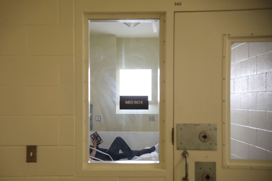 An inmate reads a book while in the infirmary at a detention facility in California, April 2020. (Getty/Sandy Huffaker)