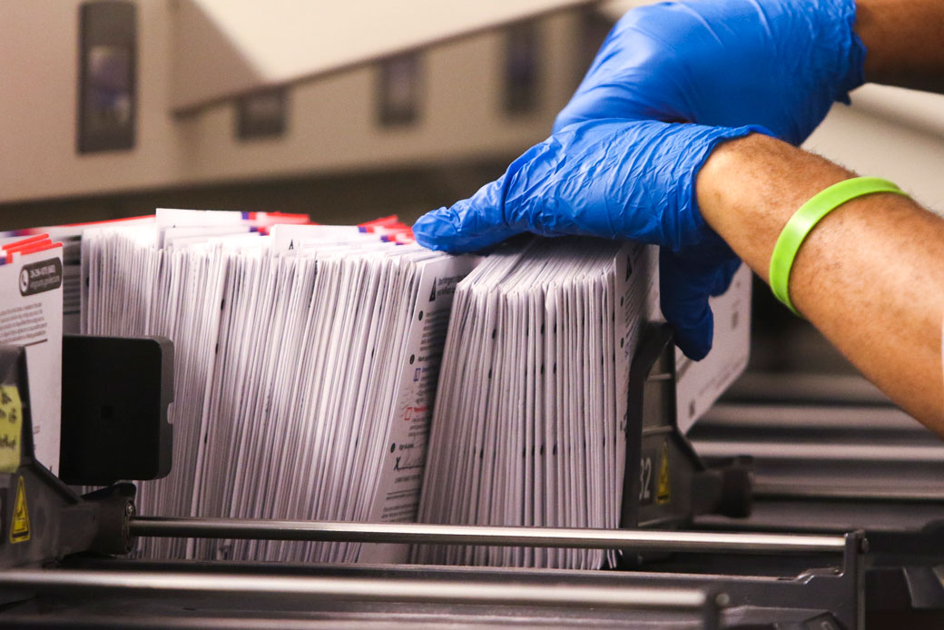 An election worker handles vote-by-mail ballots in Renton, Washington, on March 10, 2020. (Getty/Jason Redmond/AFP)