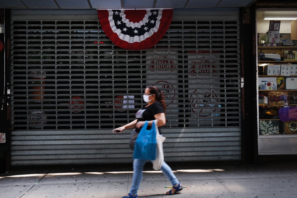 A woman walks by stores, many closed, in the Bronx in New York City on July 23, 2020. (Getty/Spencer Platt)