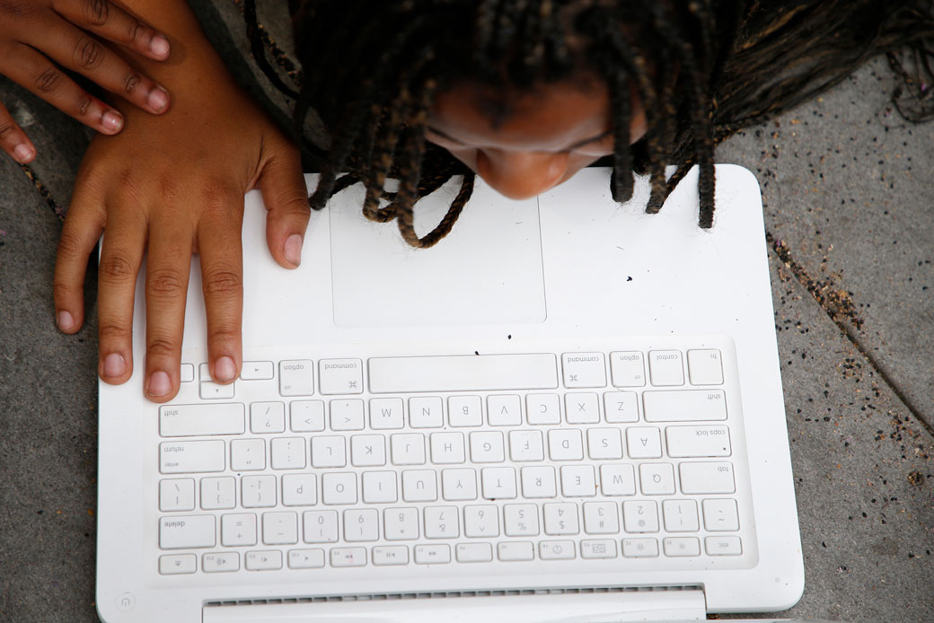 A student leans over her laptop while working on a project in Oakland, California, in August 2017. (Getty/Aric Crabb)