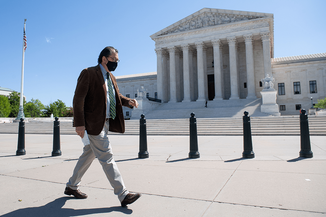 A man wearing a face mask walks in front of the U.S. Supreme Court in Washington, D.C., on May 4, 2020—the first day of oral arguments held by telephone in the court's history. (Getty/Saul Loeb)