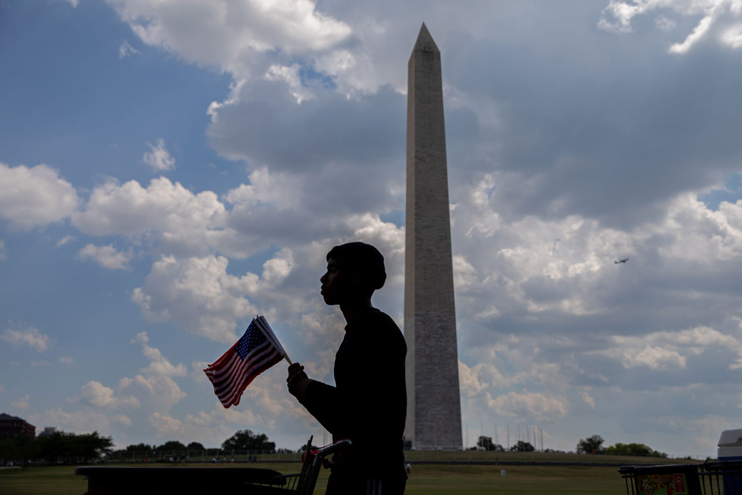 A 16-year-old high school student in Washington, D.C., sells American flags near the Washington Monument on the Fourth of July, 2020. (Getty/Evelyn Hockstein/The Washington Post)