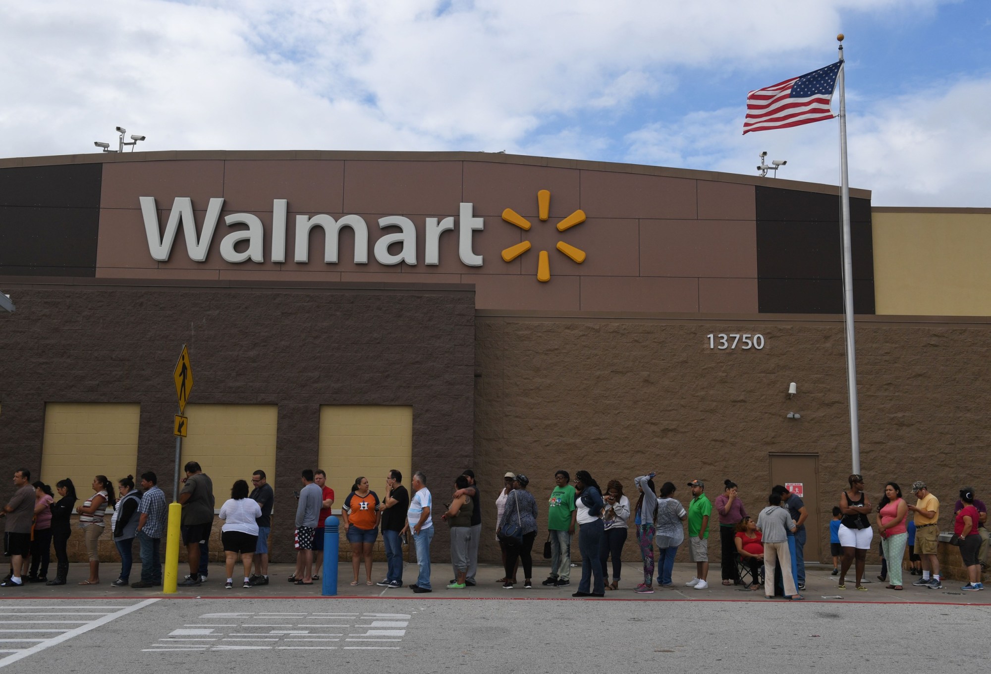 People wait in line for a Walmart store to open after Hurricane Harvey caused heavy flooding in Houston, Texas on August 30, 2017.
Monster storm Harvey made landfall again Wednesday in Louisiana, evoking painful memories of Hurricane Katrina's deadly strike 12 years ago, as time was running out in Texas to find survivors in the raging floodwaters. / AFP PHOTO / MARK RALSTON        (Photo credit should read MARK RALSTON/AFP via Getty Images)