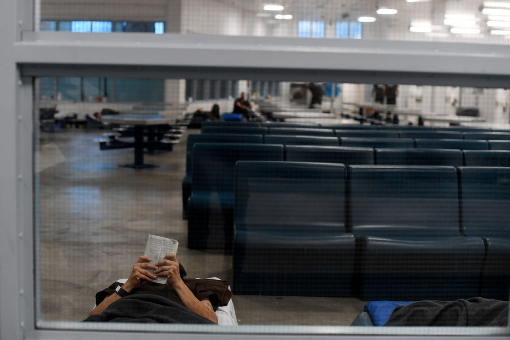 An inmate reads on the floor at a detention center on December 6, 2017. (Getty/AAron Ontiveroz/The Denver Post)