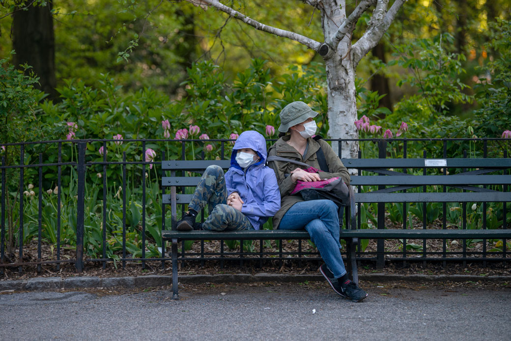 A mother and child sit on a bench in Central Park amid the COVID-19 pandemic, New York, May 2020. (Getty/Alexi Rosenfeld)