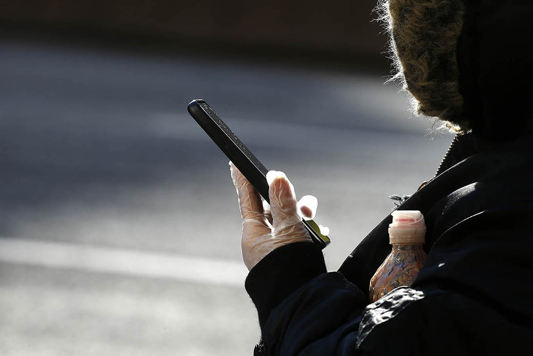 A woman wears a plastic glove while holding her cell phone during the coronavirus pandemic, April 9, 2020, in New York City. (Getty/John Lamparski)