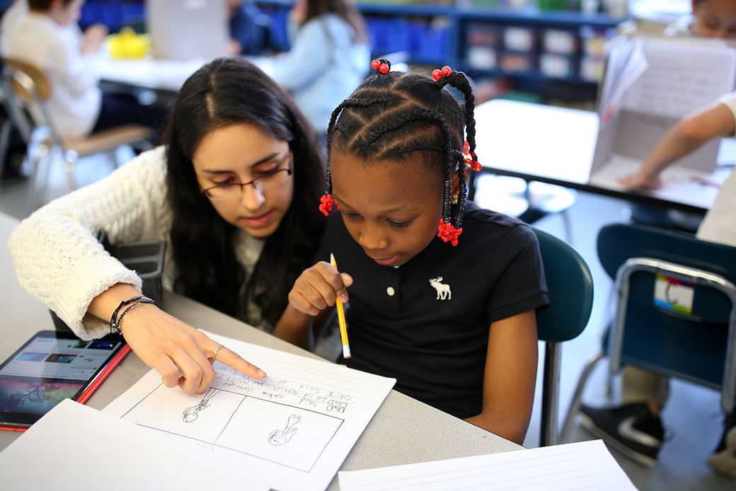 A first-grade teacher works with a student during an English literacy class at a school in Boston, April 2016. (Getty/The Boston Globe/Jonathan Wiggs)