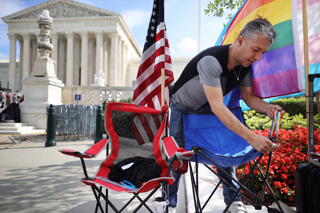 A man attaches a safety whistle to his chair while waiting in line outside the U.S. Supreme Court building for a chance to attend the Bostock v. Clayton arguments, October 2019.