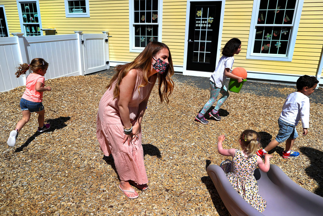 A teacher keeps an eye on children playing at Magical Beginnings Learning Academy in Middleton, Massachusetts, May 2020. (Getty/The Boston Globe/John Tlumacki)