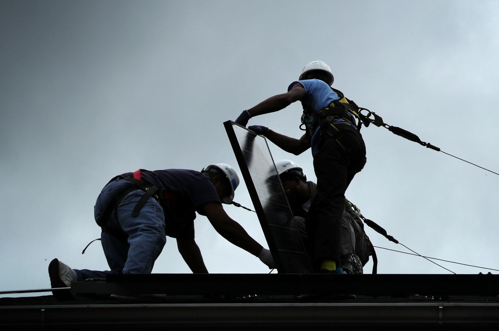 WASHINGTON, DC - MAY 03:  Workers put solar panels down during an installation May 3, 2106 in Washington, DC. The installation marked the one millionth in the U.S. in the past 40 years. It has been predicted that the U.S. will reach 2 million installations in two years.  (Photo by Alex Wong/Getty Images)