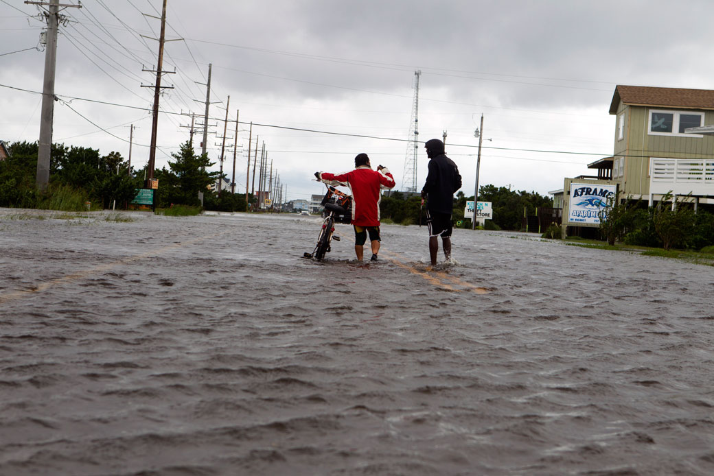 Two people walk down a flooded street in Rodanthe, North Carolina, as Hurricane Dorian hits Cape Hatteras on September 6, 2019.