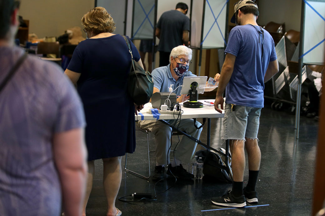 A poll worker assists voters during early voting in Boston on August 25, 2020. (Getty/The Boston Globe/Jonathan Wiggs)