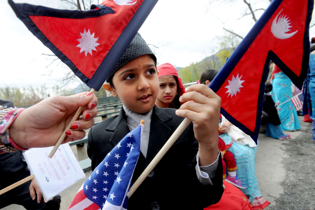  (A young boy prepares to carry the Nepali and the U.S. flags in the Nepal Day Parade in downtown Boulder, Colorado, April 2015.)