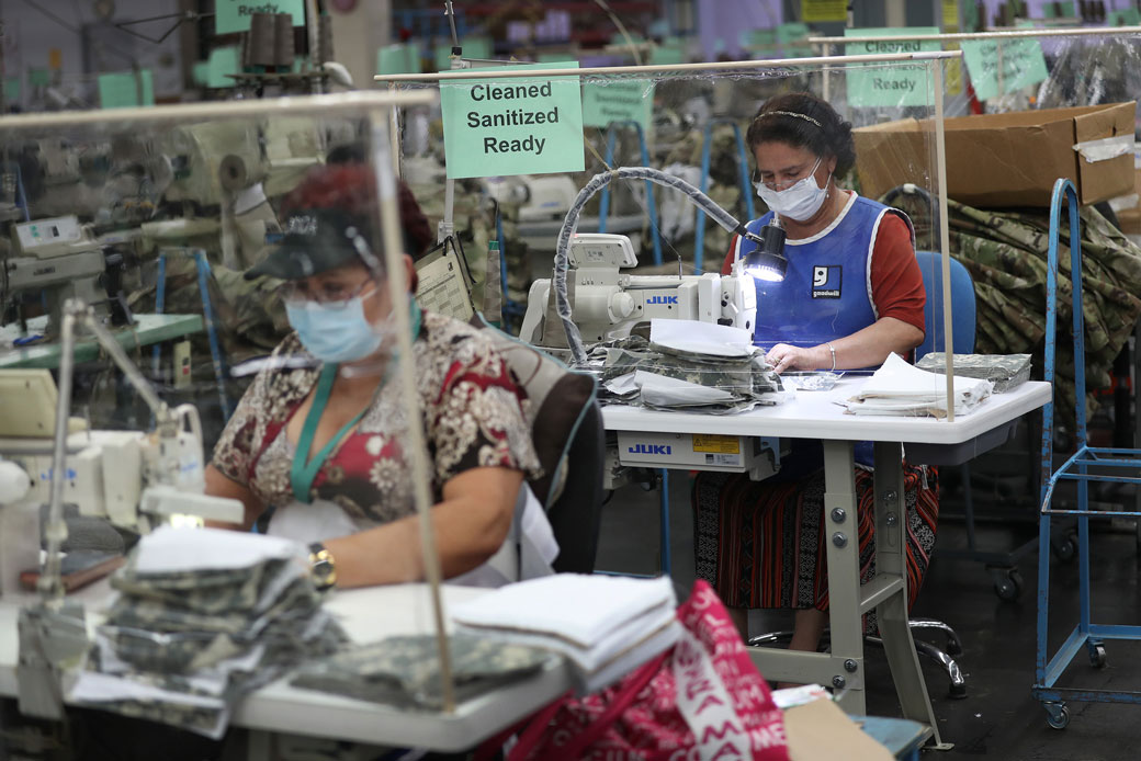  (Two women use sewing machines to put together protective masks for medical personnel working in hospitals in Miami on April 15, 2020.)