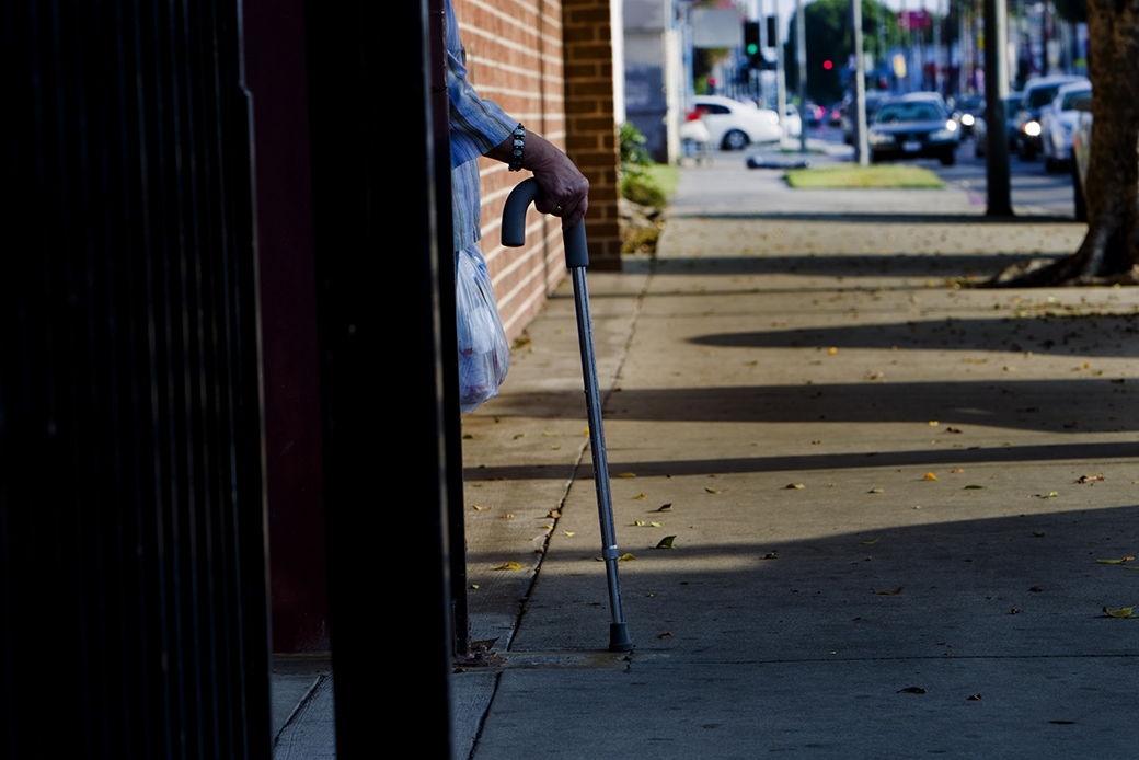 Holding onto her cane, a patient waits for a ride after a doctor's appointment in Los Angeles. (Getty/Gina Ferazzi)