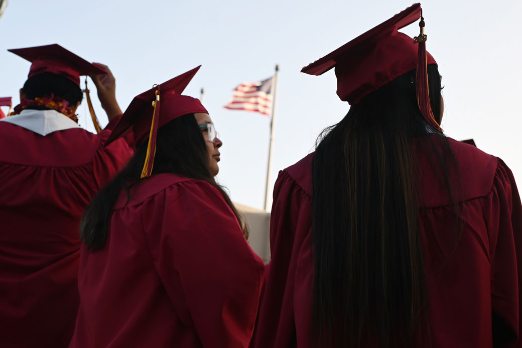 A U.S. flag flies above a building as students participate in a graduation ceremony in Pasadena, California, on June 14, 2019. (Getty/AFP/Robyn Beck)